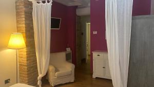 San Giorgio Di MantovaにあるAgriturismo Corte Roccaの紫の壁と白いカーテンが特徴のベッドルーム