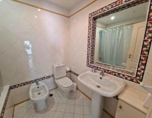 La salle de bains est pourvue d'un lavabo, de toilettes et d'un miroir. dans l'établissement Praia Oura Sunset, à Albufeira