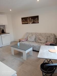 ein Wohnzimmer mit einem Sofa und einem Tisch in der Unterkunft Studio HELTYMIE 4-Vélos bienvenus-parking gratuit in Portiragnes