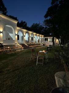 um edifício com uma mesa e cadeiras à noite em La Posta del Jesuita em Villa Los Aromos