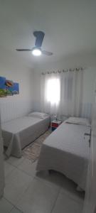 a bedroom with two beds and a ceiling fan at Vila Monrealle in Ubatuba +40 photos