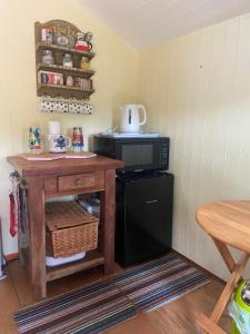 a small kitchen with a microwave and a table at Tyluna Cornish Cabin in Praze an Beeble