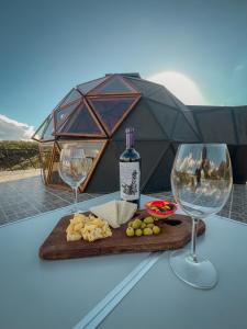 a table with a bottle of wine and two glasses at Domos Zen in Estancia Grande
