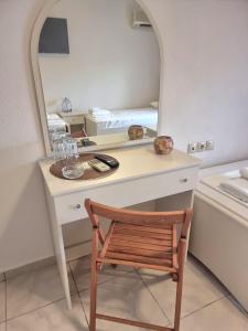 Habitación con escritorio con silla y espejo. en Hotel Nautilos, en Sozopoli