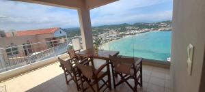 a balcony with a table and chairs and the ocean at Villa Dina Apartments in Almirida