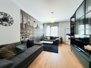 a living room with a couch and a clock on the wall at Old Town Residence Gdansk in Gdańsk
