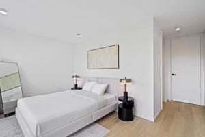 een witte slaapkamer met een bed en een lamp bij Chic 80sqm Luxe Apt - Heart of Luxembourg City in Luxemburg