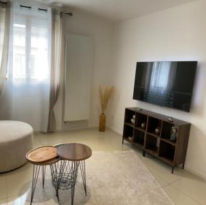 a living room with two tables and a flat screen tv at Kezy appartement 4 personne bébé in Reims