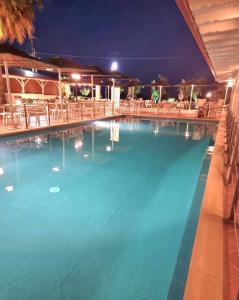 a large swimming pool at night with tables and chairs at Hotel Nautilos in Sozopoli