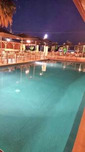 una gran piscina de agua azul por la noche en Hotel Nautilos, en Sozopoli