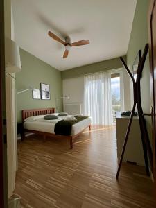 une chambre avec un lit et un ventilateur de plafond dans l'établissement Lake House La Gemma, à Riva del Garda