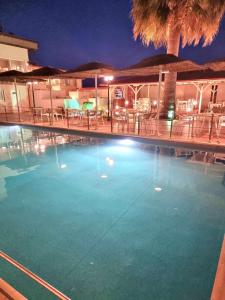 a large swimming pool with tables and chairs at night at Hotel Nautilos in Sozopoli