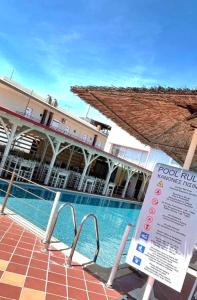 una piscina con una señal frente a un edificio en Hotel Nautilos, en Sozopoli