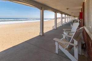 a row of chairs sitting on the beach at Cavalier by the Sea in Kill Devil Hills