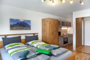 two beds in a room with a kitchen at Apartment Biendl in Mittenwald