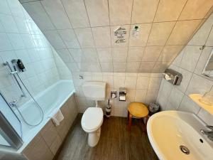 La salle de bains est pourvue de toilettes, d'un lavabo et d'une baignoire. dans l'établissement Aalreuse, à Rostock
