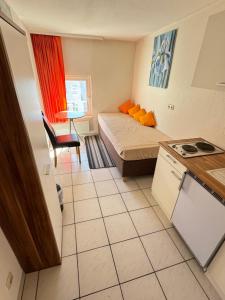 ein kleines Zimmer mit einem Bett und einer Küche in der Unterkunft Aalreuse in Rostock