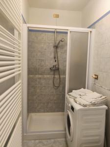 a bathroom with a shower and a washing machine at Casa Relax in Bellano