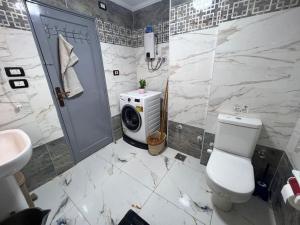 a bathroom with a toilet and a washing machine at A luxury apartment fully nile view -Downtown Cairo in Cairo