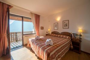 sypialnia z łóżkiem i dużym oknem w obiekcie HG Hotel Italia w mieście Brusson