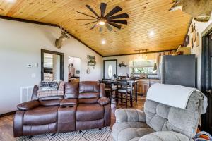 a living room with a leather couch and a kitchen at Arkansas Retreat with Deck, Fire Pit and Mtn Views! in Jasper