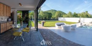 a kitchen and living room with a table and chairs at Villa Mermaid of Una in Bihać