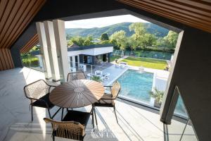 a patio with a table and chairs and a swimming pool at Villa Mermaid of Una in Bihać