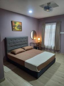 a bedroom with a large bed and a window at Tambun Homestay in Tambun