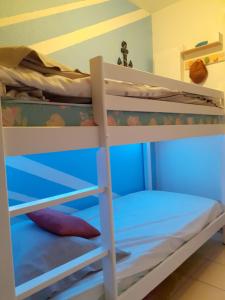 two bunk beds in a room with a blue at joli studio cabine 4 personnes à 300 m de la plage in Argelès-sur-Mer