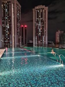 una piscina en la cima de una ciudad por la noche en Chambers Suites KL BY Fortune en Kuala Lumpur