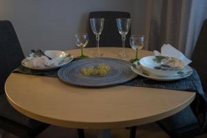 stół z talerzem jedzenia i kieliszkami do wina w obiekcie Aurinkolahti cosy apartment with warm parking w Helsinkach