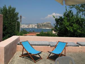 two blue chairs sitting next to a wall with a bench at La casa di Vittorio de Feo in Procida