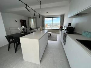 a kitchen and living room with a table and a counter at Duplex Penthouse Qawra Malta in St. Paul's Bay