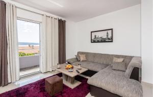 a living room with a couch and a large window at Stunning Apartment In Crikvenica With Kitchen in Crikvenica
