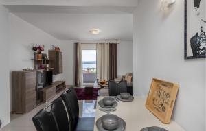 a living room with a table and some chairs at Stunning Apartment In Crikvenica With Kitchen in Crikvenica