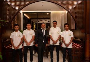 un grupo de hombres parados junto a un hombre de traje en فندق ايليت الهجرة en Medina