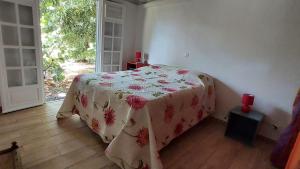 Un dormitorio con una cama con una manta de flores. en Cotton residences, en Sainte-Anne