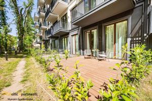 a wooden deck in front of a building at Seaside Garden Apartments & Wellness by Baltic Apartments in Świnoujście