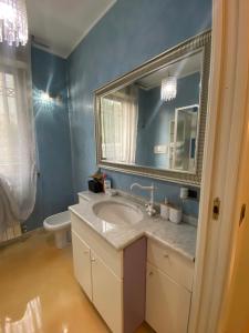 a bathroom with a sink and a mirror and a toilet at Appartamento con Giardino in Seregno
