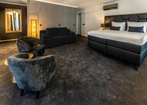 a hotel room with a bed and a chair at Square Boutique Hotel & Brasserie in Venray