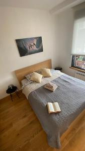 um quarto com uma cama com dois livros em Apartment Unamare em Belgrado