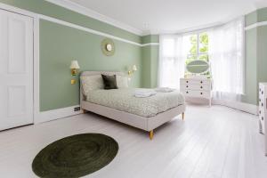 a white bedroom with a bed and a rug at Guest Homes - The Grove in Hartlepool