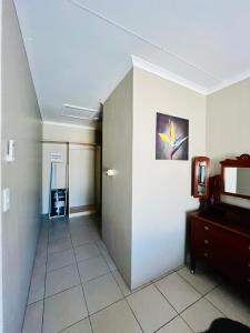 a room with a hallway with a mirror and a room with a treadmill at Ivanka's Self-Catering Flat in Kimberley