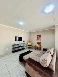 a bedroom with a bed and a flat screen tv at Ivanka's Self-Catering Flat in Kimberley