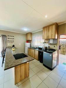 une grande cuisine avec des placards en bois et un comptoir. dans l'établissement Ivanka's Self-Catering Flat, à Kimberley