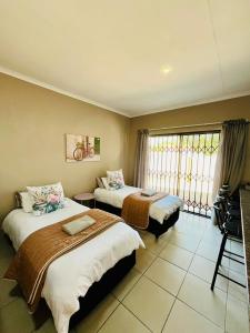 una camera d'albergo con due letti e una finestra di Ivanka's Self-Catering Flat a Kimberley