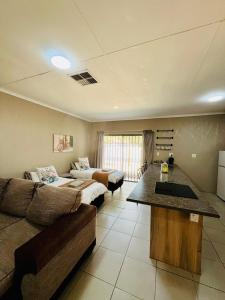 sala de estar amplia con sofá y cama en Ivanka's Self-Catering Flat, en Kimberley