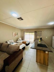 a large living room with a couch and a bed at Ivanka's Self-Catering Flat in Kimberley