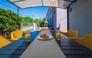 uma mesa com um prato de comida e dois copos de sumo de laranja em Gorgeous Apartment In Pula With Kitchen em Muntić