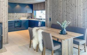 a kitchen with a wooden table and blue cabinets at Lovely Home In Hnefoss With Kitchen in Hønefoss